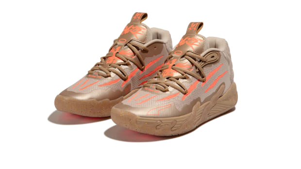 Side view of LaMelo Ball's gold and red PUMA sneakers.